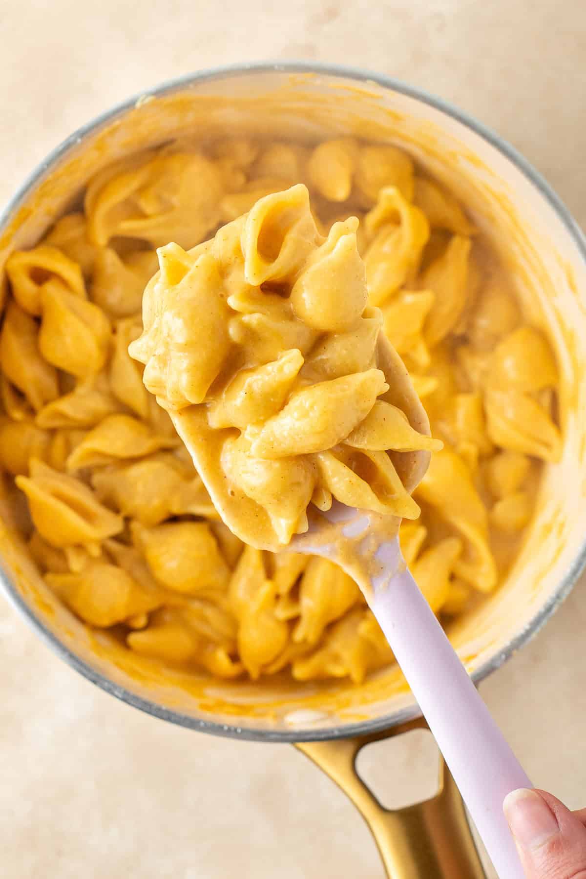 Mixing the cooked pasta through the sauce.