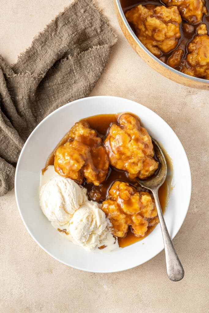The golden syrup dumplings served in a bowl with ice cream.
