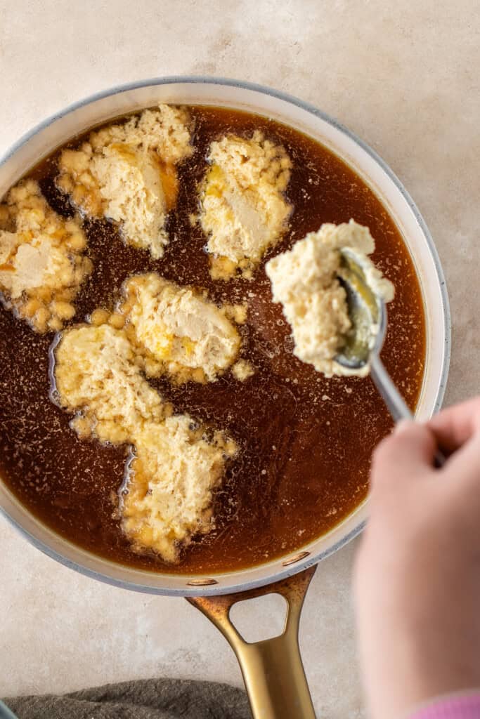 Dropping the dumpling dough into the saucepan.