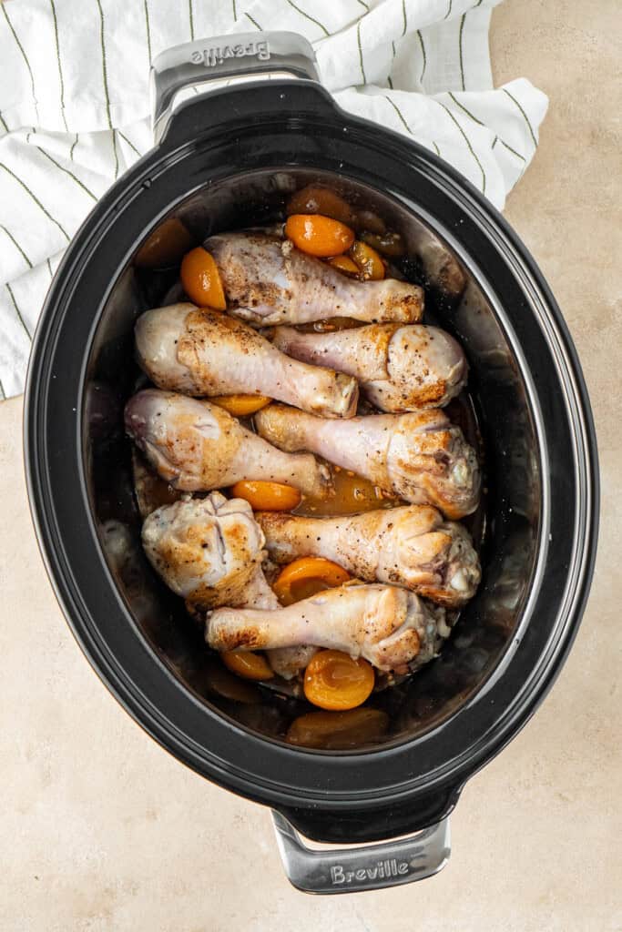Adding the chicken to the slow cooker.