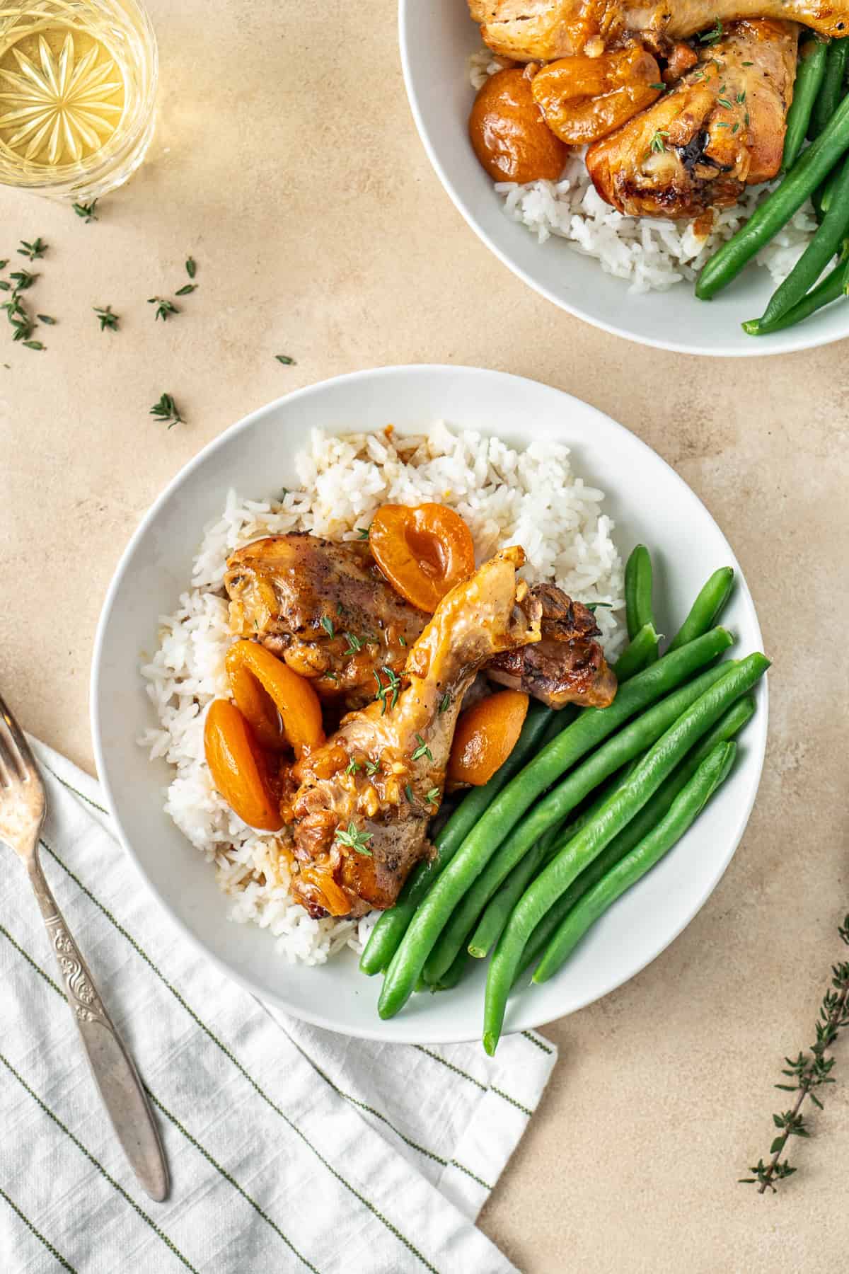 Apricot chicken drumsticks served with beans and rice.