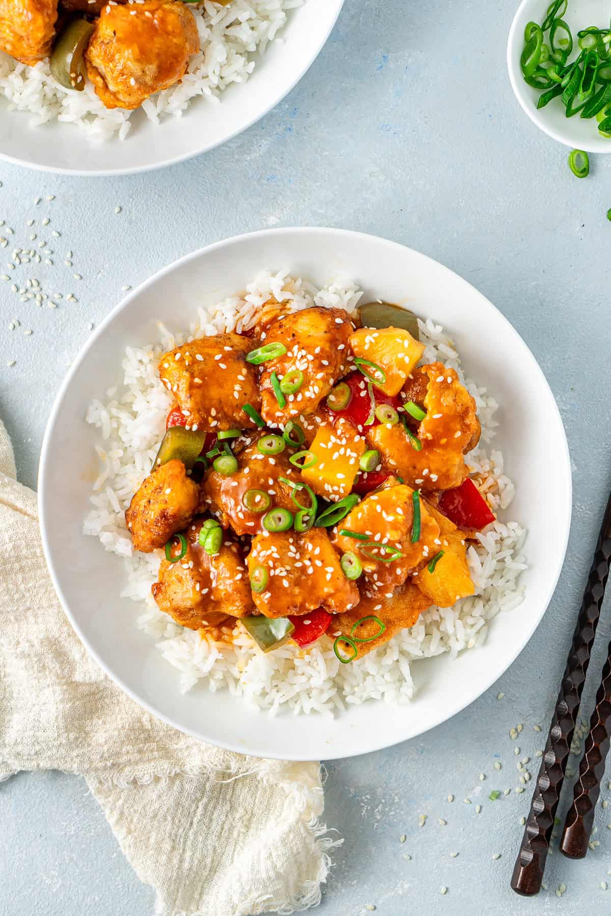 Sweet and sour chicken in bowls with rice.