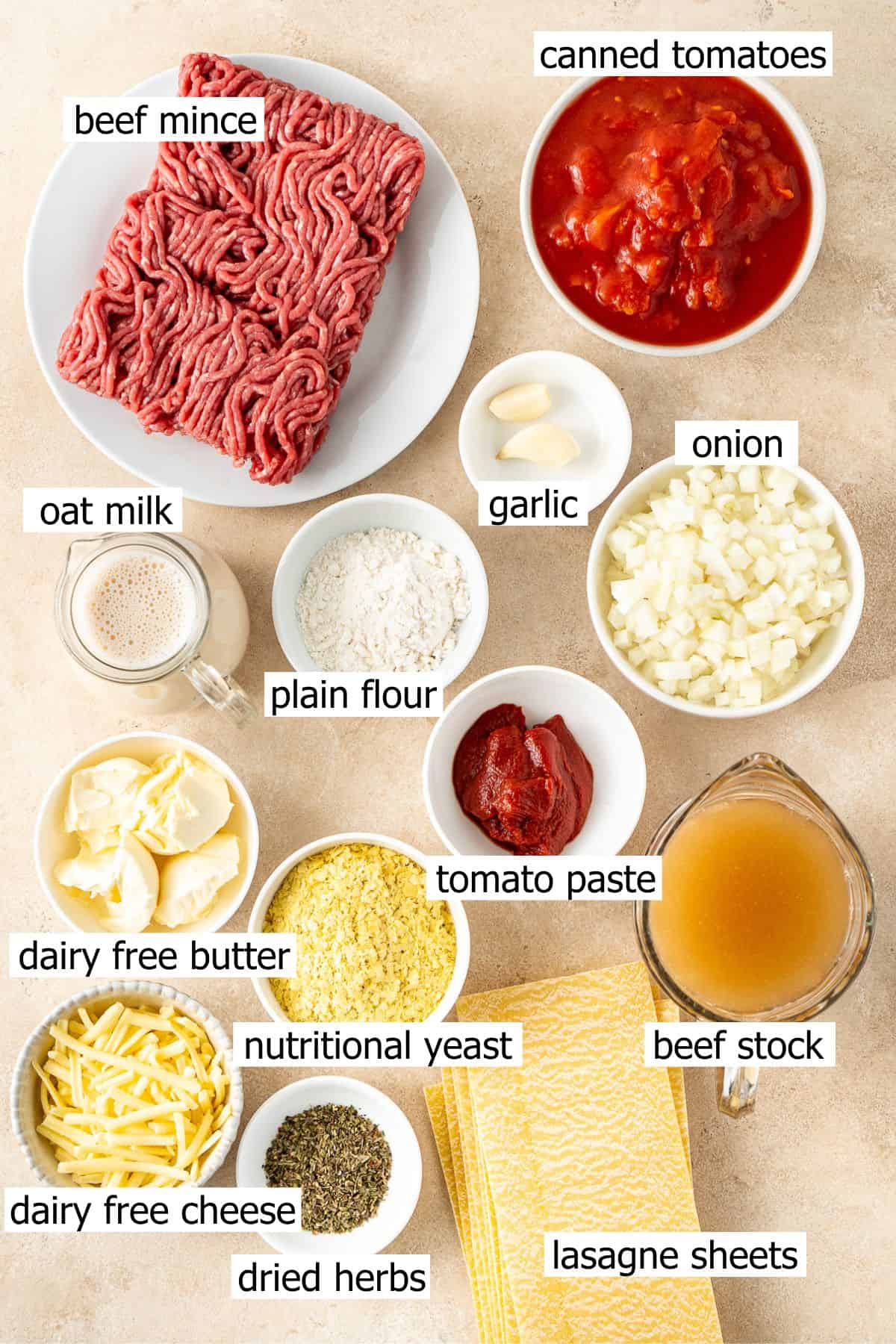 All ingredients needed to make lasagne laid out in small bowls.