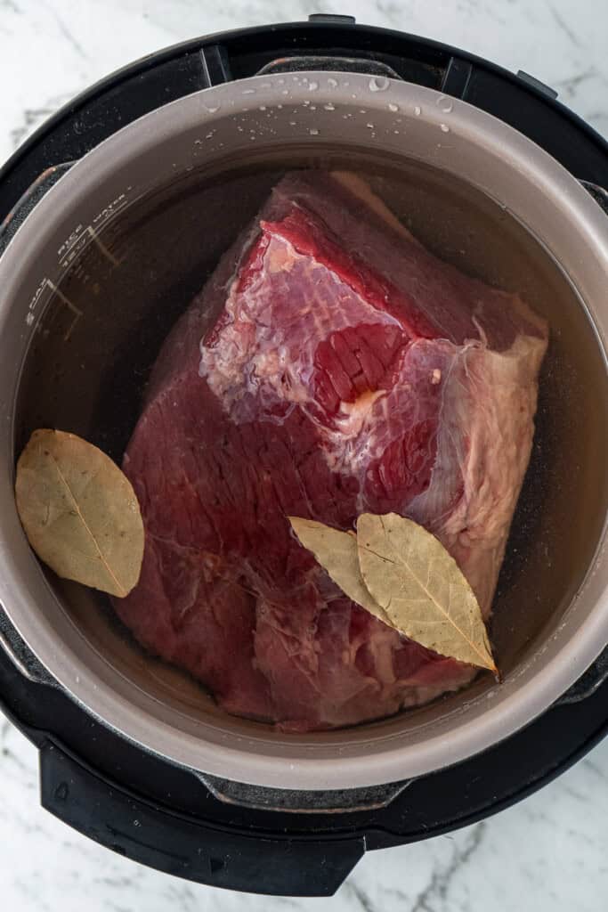 The raw corned beef in the slow cooker.