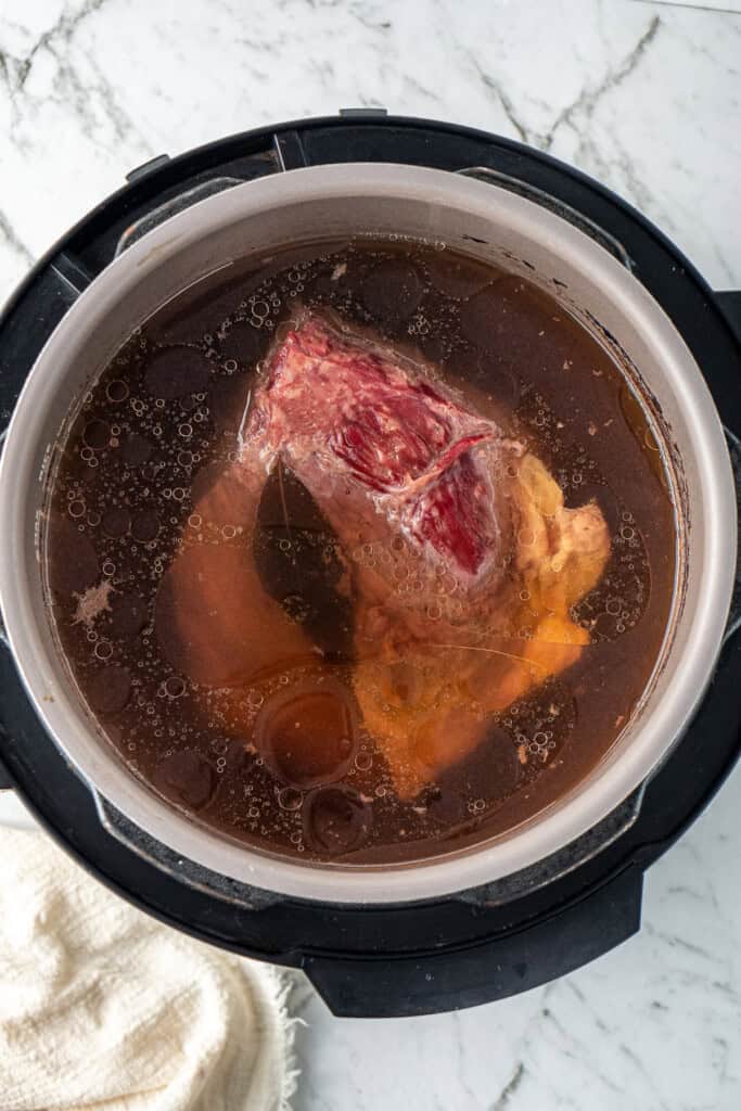 The cooked corned beef in the pressure cooker.