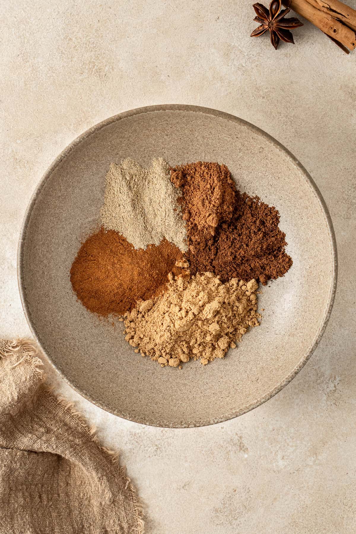 All the spices for chai spice in a bowl.
