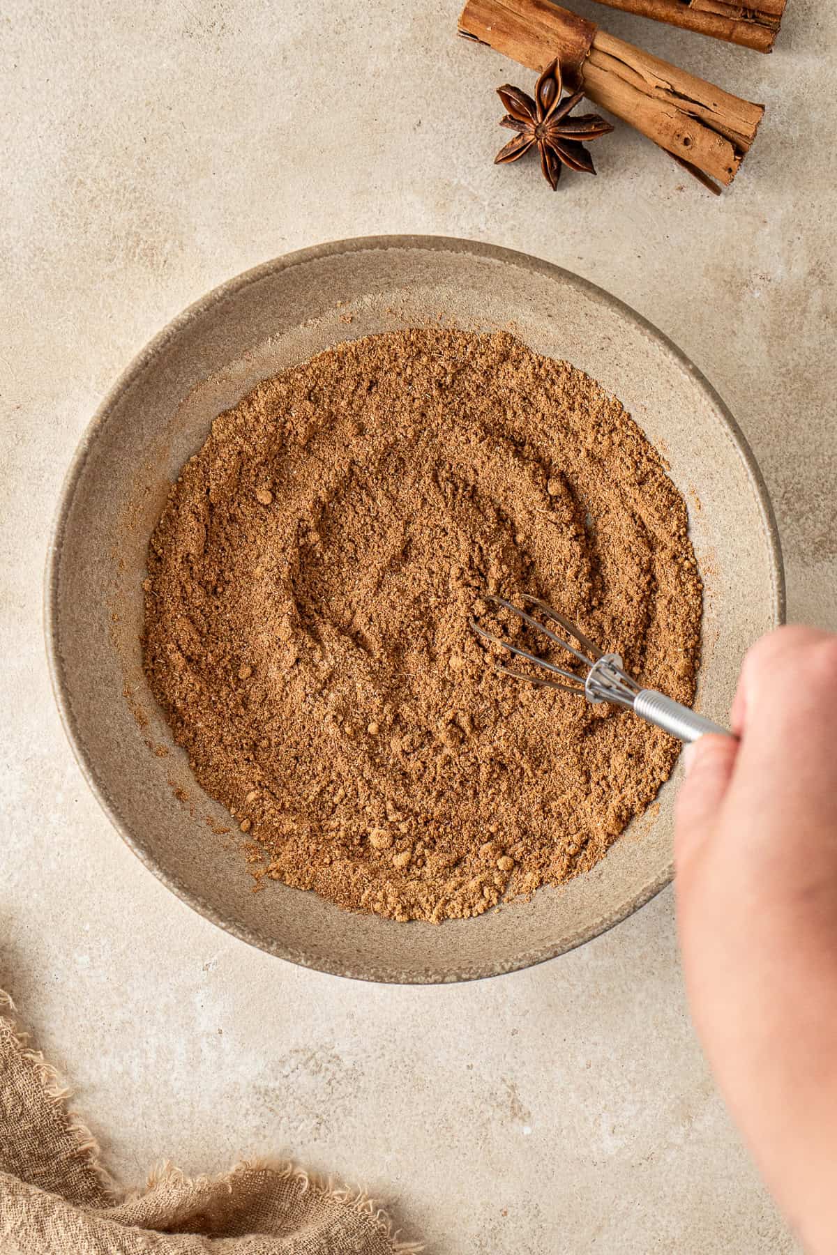 Mixing together the spice blend in a bowl.