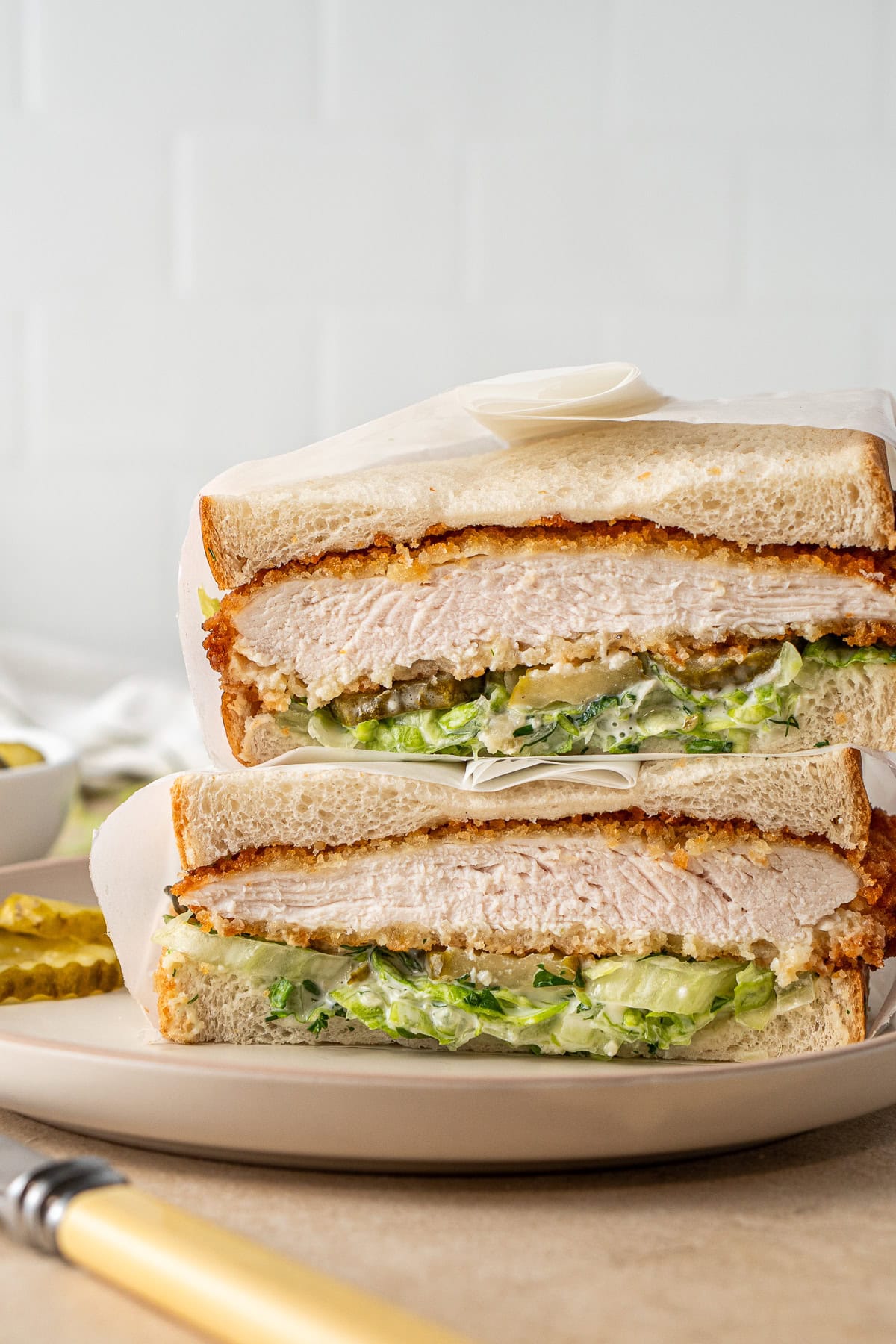 Close up of the chicken schnitzel sandwich cut in half on a plate. 