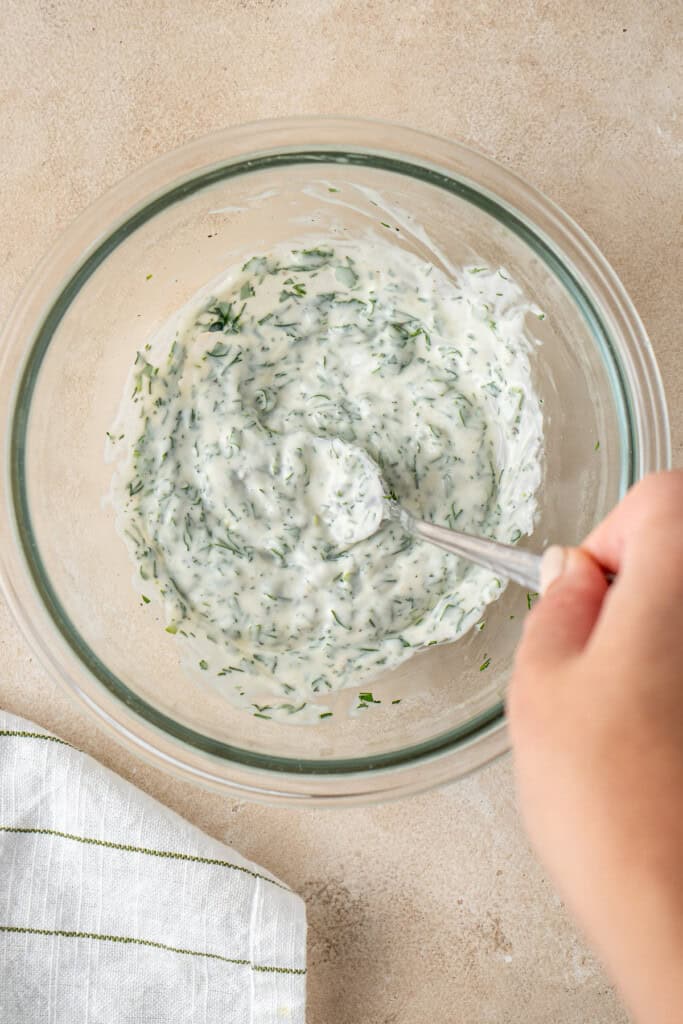 Mixing up the herb mayo in a bowl.