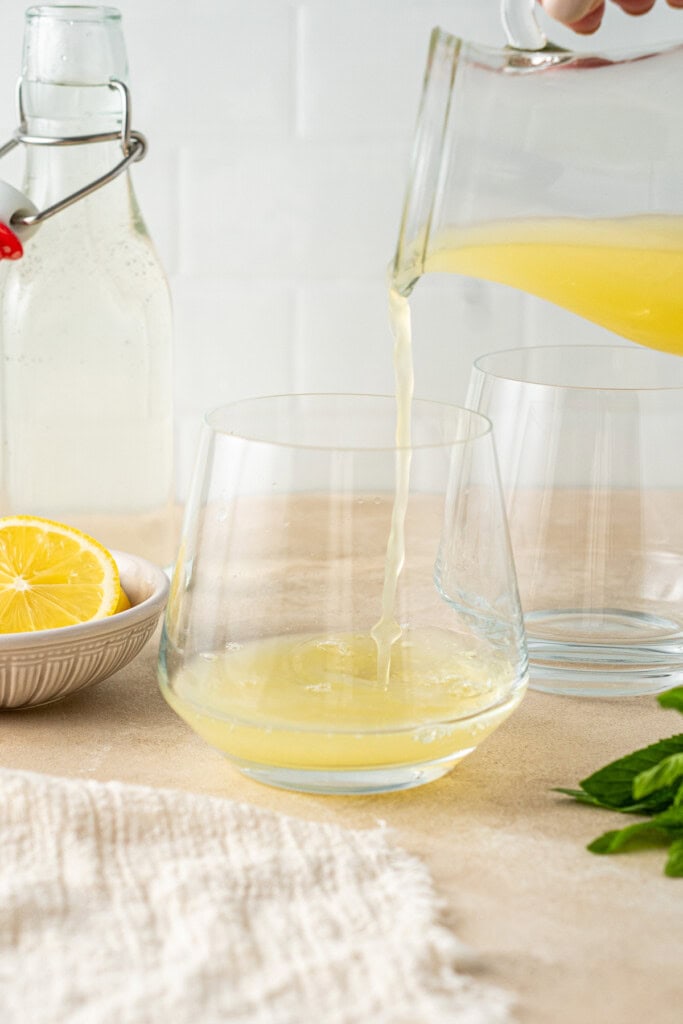 Pouring lemon juice into the glass.
