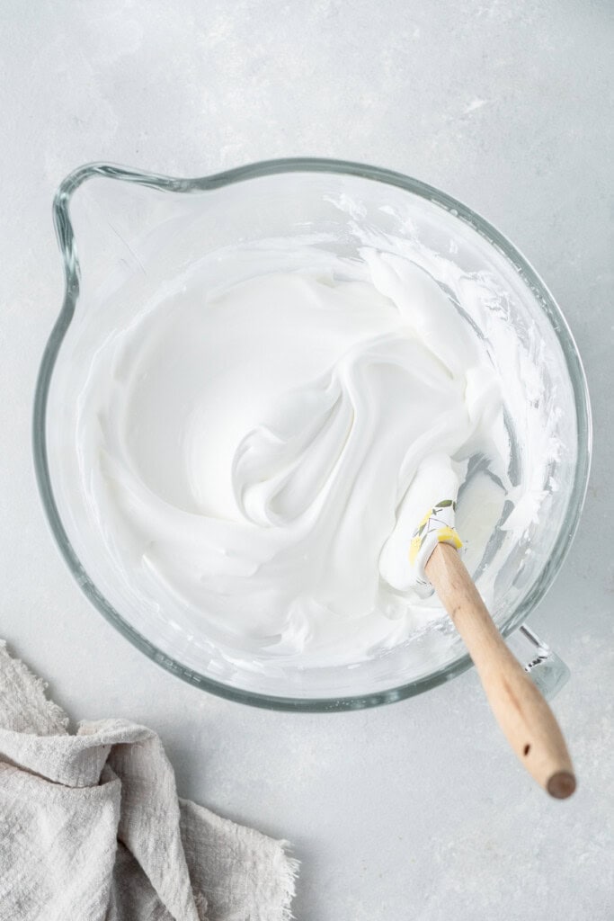 The meringue mixture in a mixing bowl with a spatula.