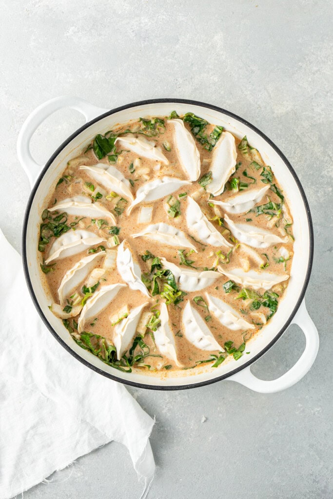 Adding the dumplings to the casserole dish.