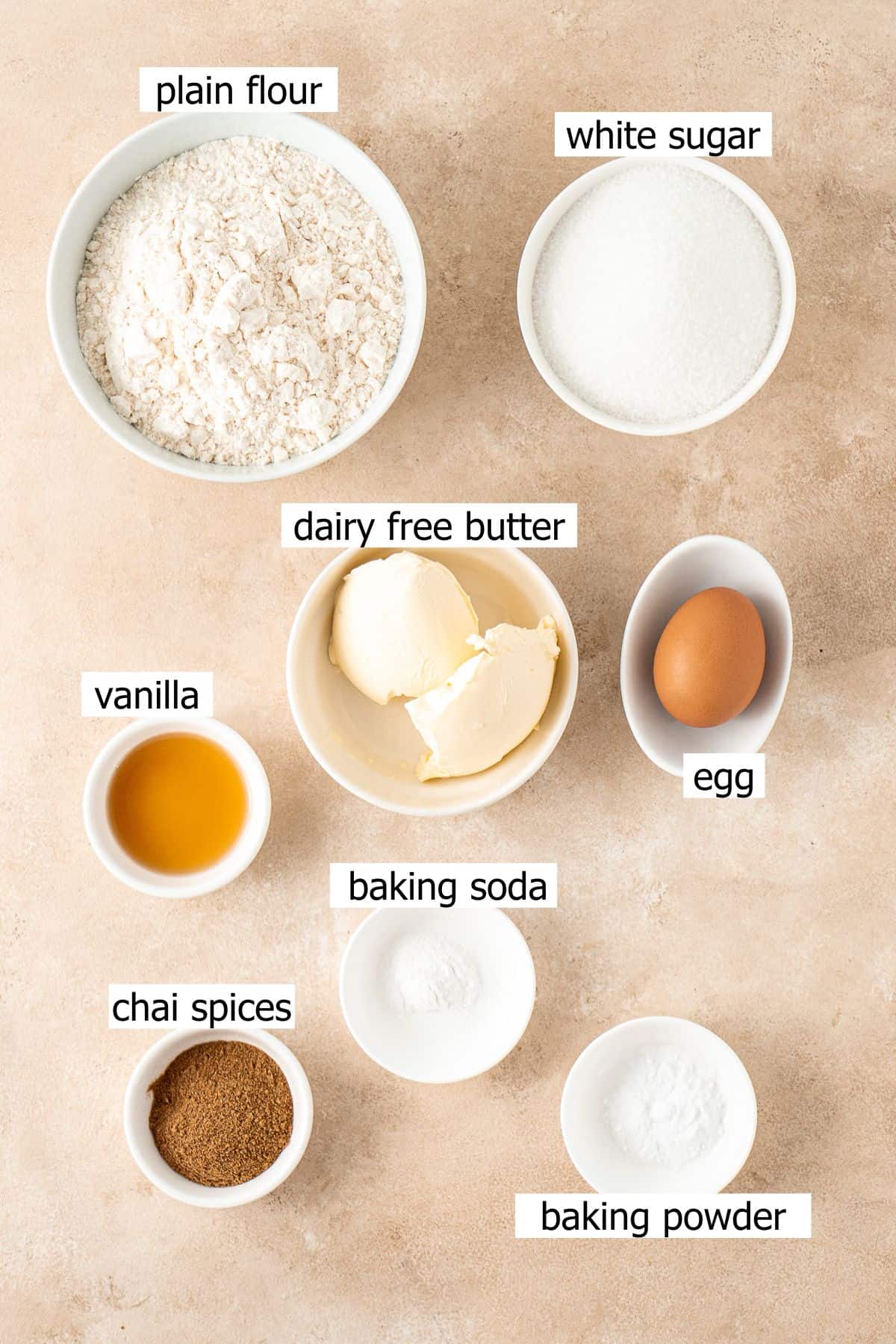 All ingredients needed to make chai sugar cookies laid out in small bowls.