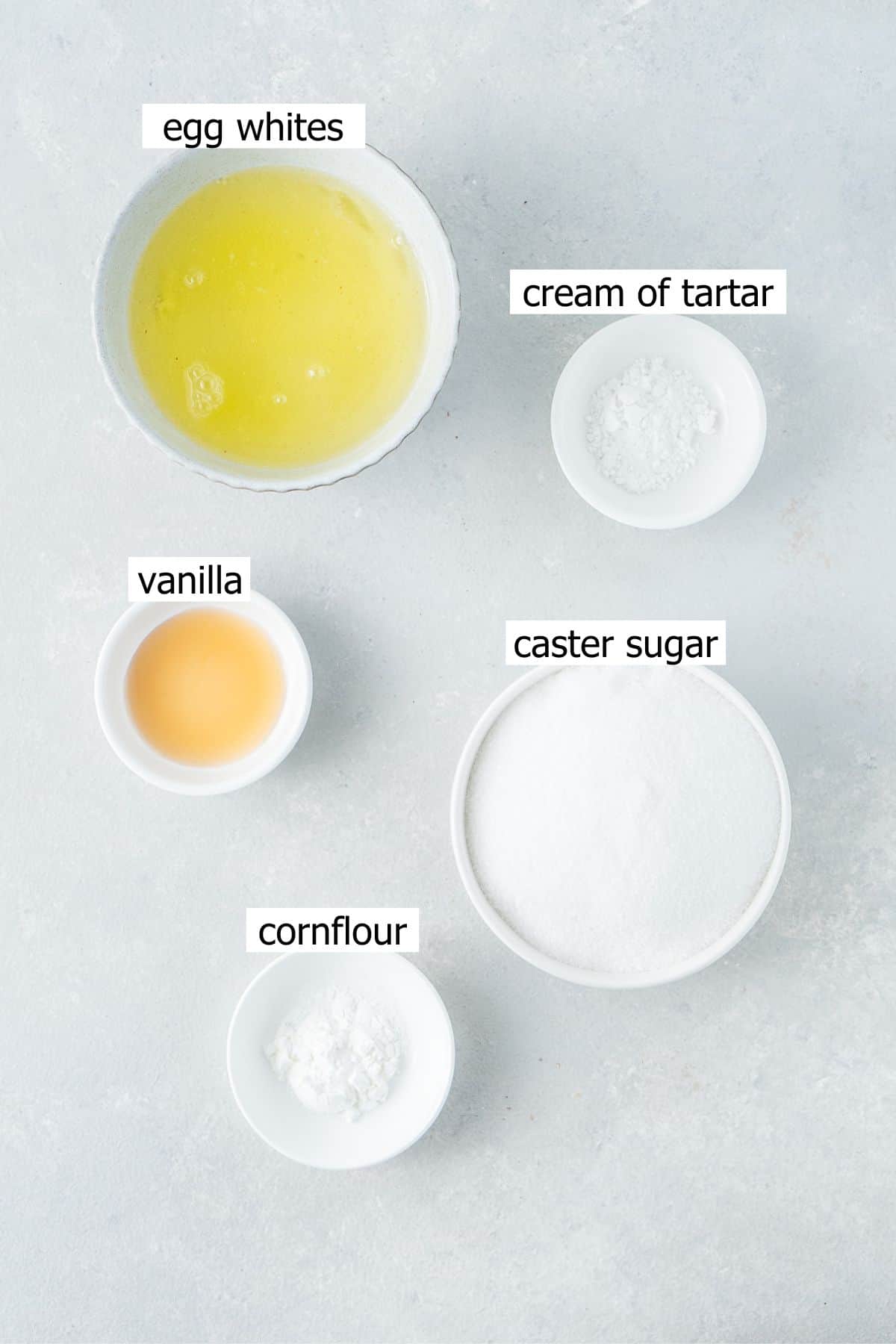 All ingredients needed to make mini pavlovas laid out in bowls.