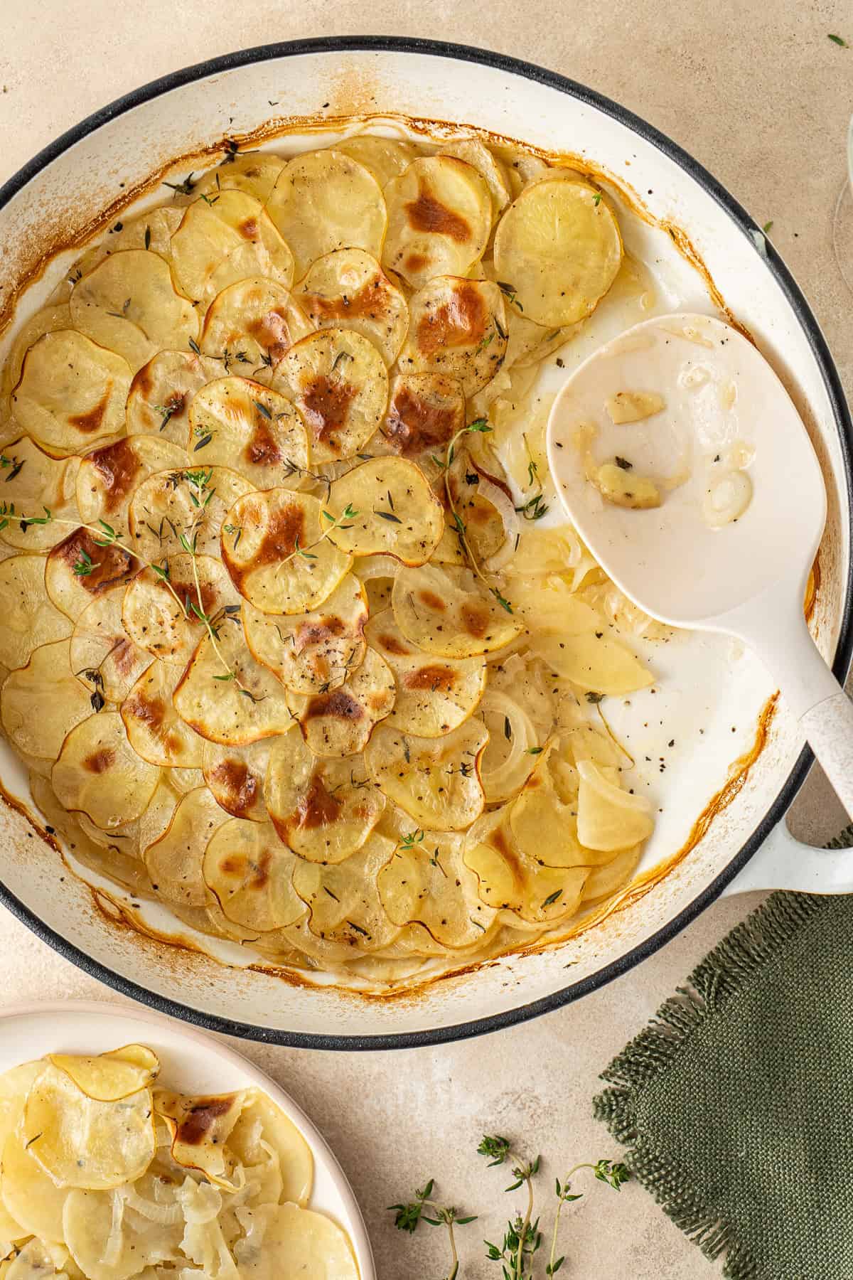 The serving spoon in the pan of dairy free potato bake.
