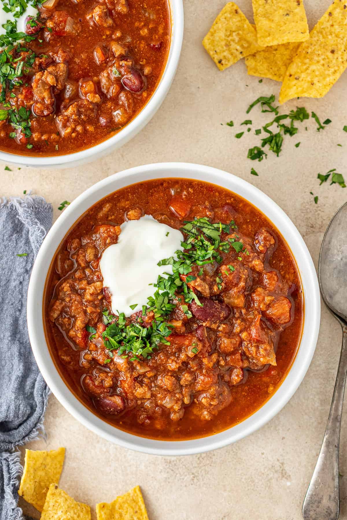 Slow cooker chilli con carne in bowls with dairy free yoghurt and fresh herbs.