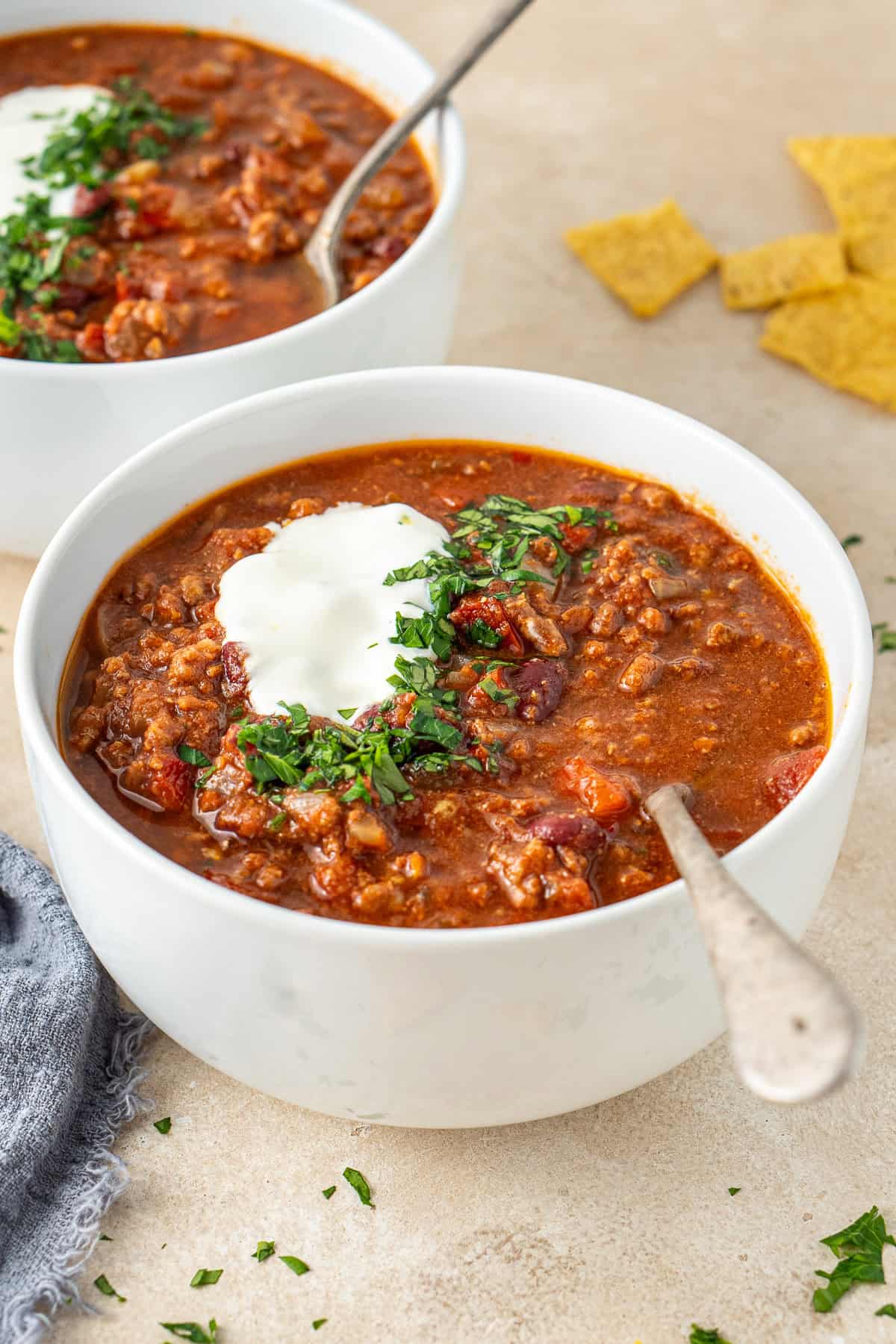 Chilli con carne in white bowls with spoons.