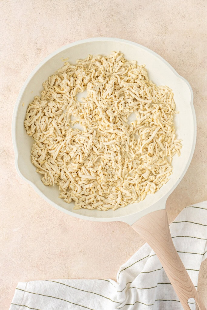 The shredded tofu in a frying pan.