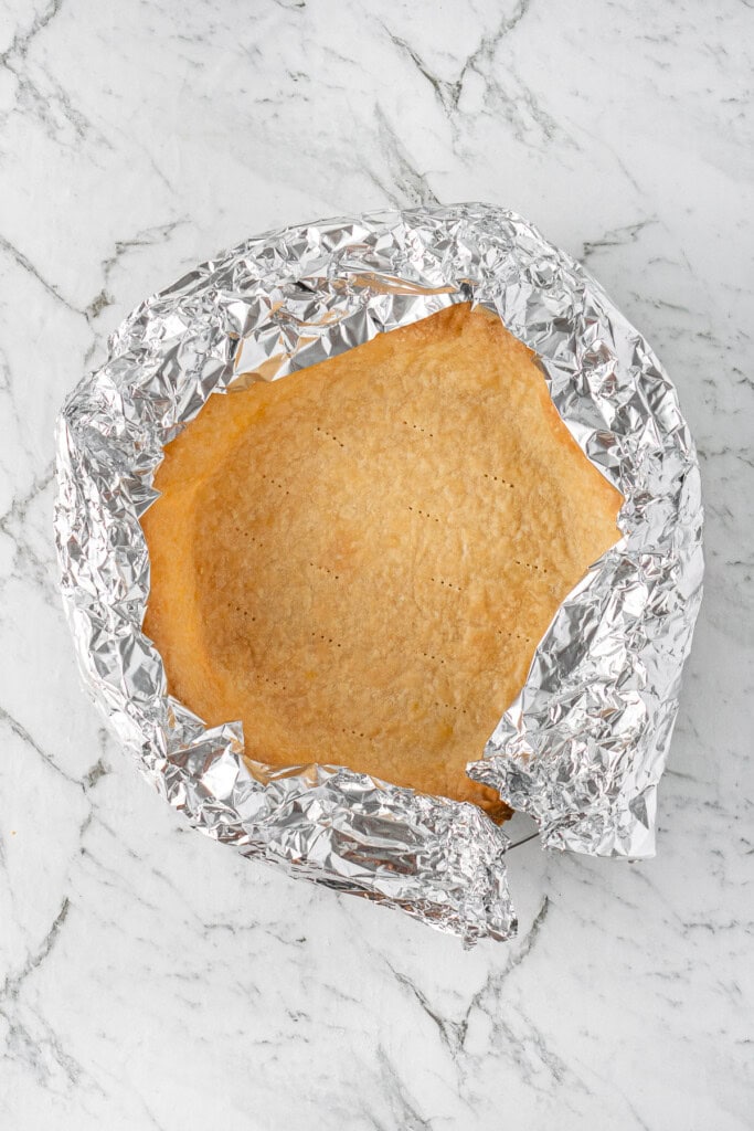 The pie crust edges covered in foil.