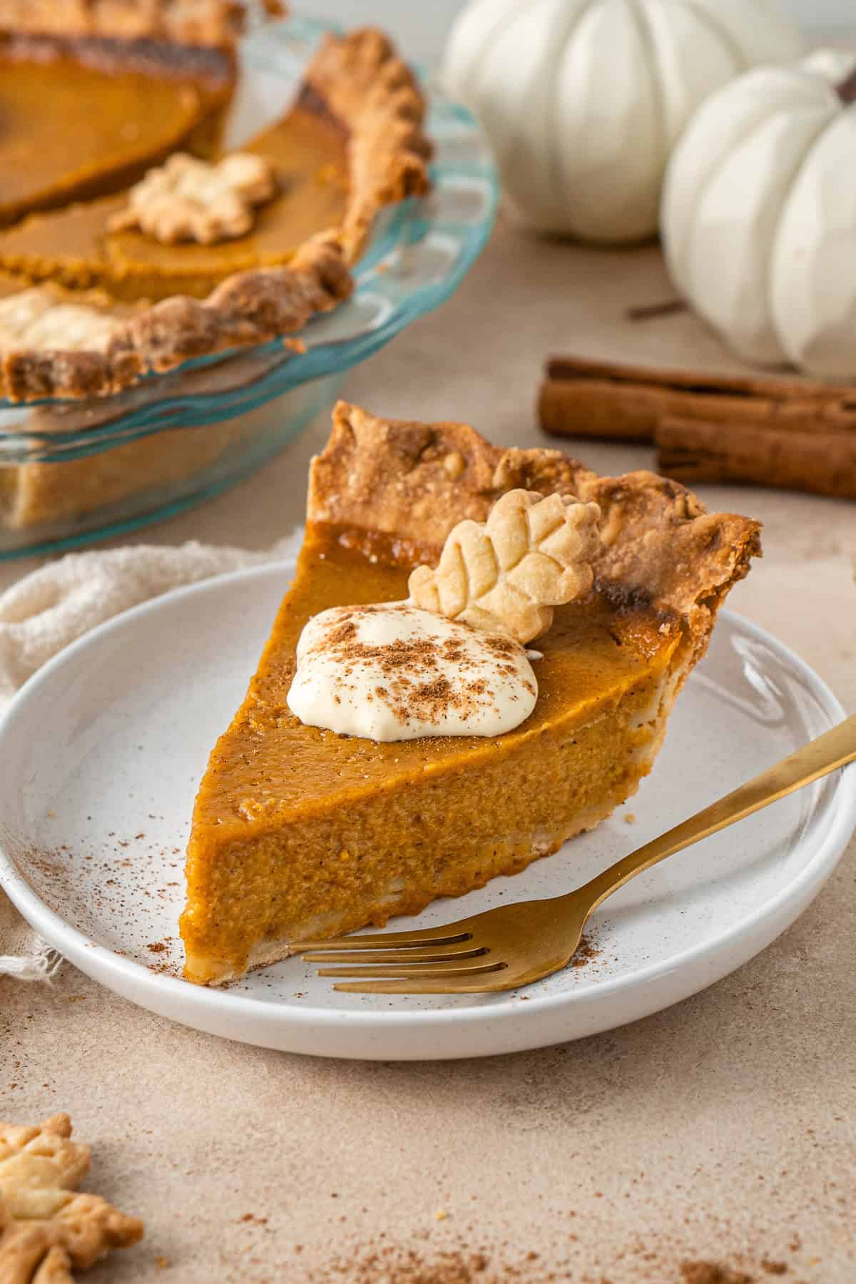 A slice of pumpkin pie on a plate with a fork.