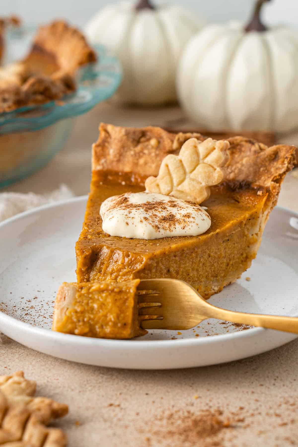A fork taking a bite of a slice of dairy free pumpkin pie.