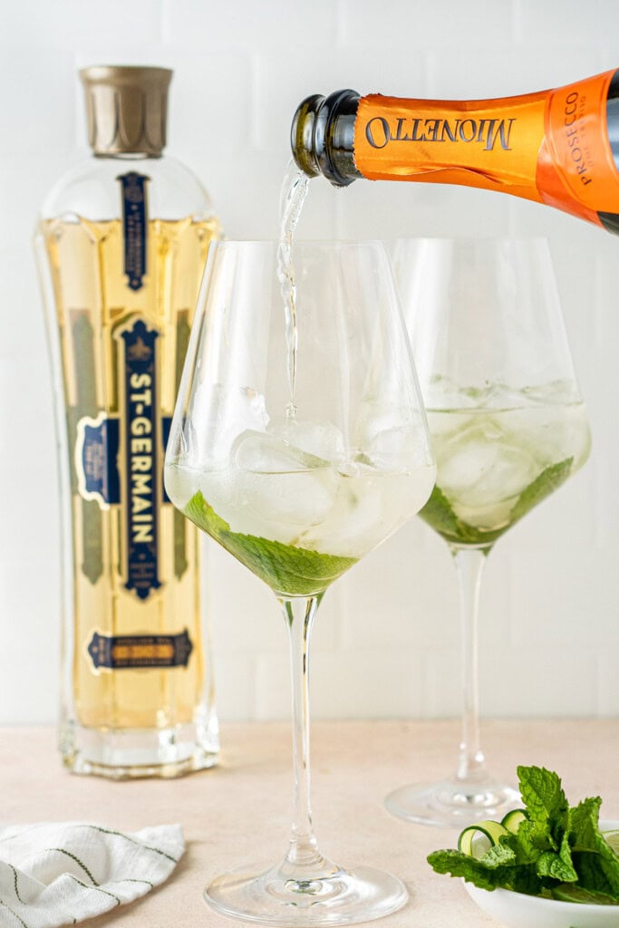 Pouring the prosecco into the glass.