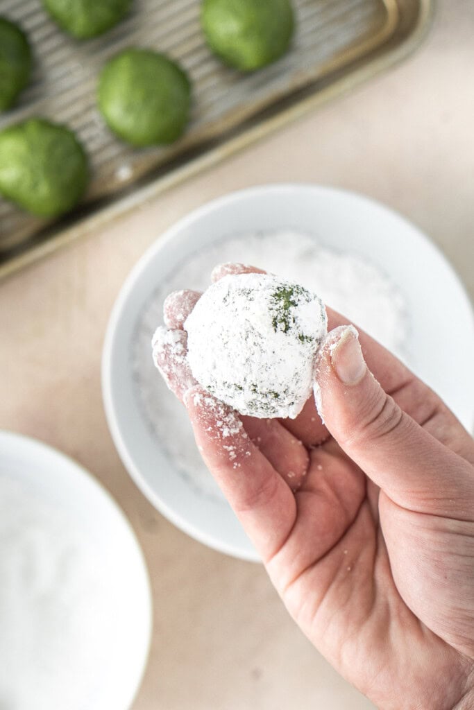 Coating the cookie balls in icing sugar.