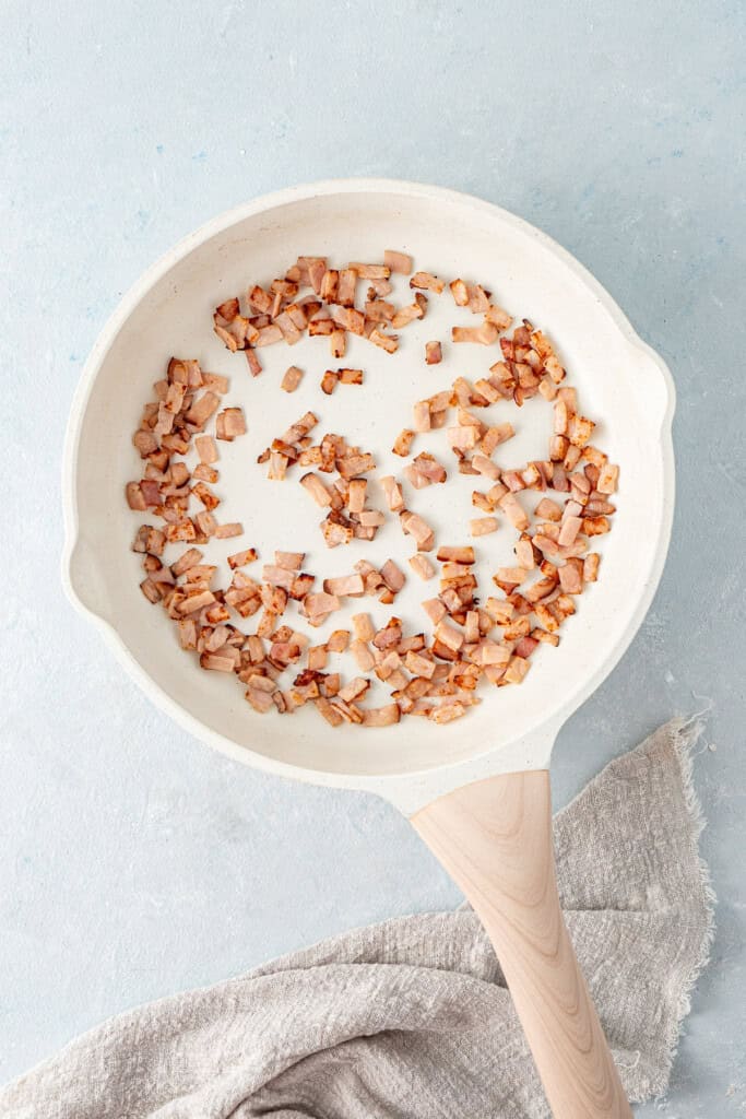 Cooking the bacon in a pan.