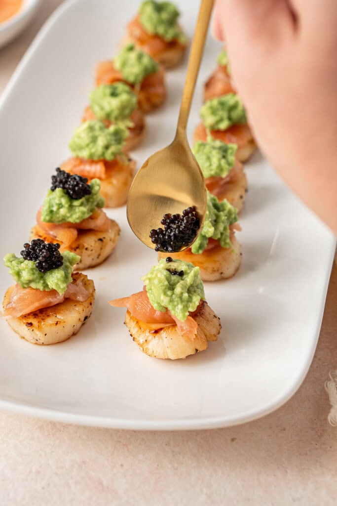 Topping the scallops with caviar. 
