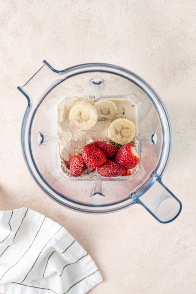 All smoothie ingredients in a blender.
