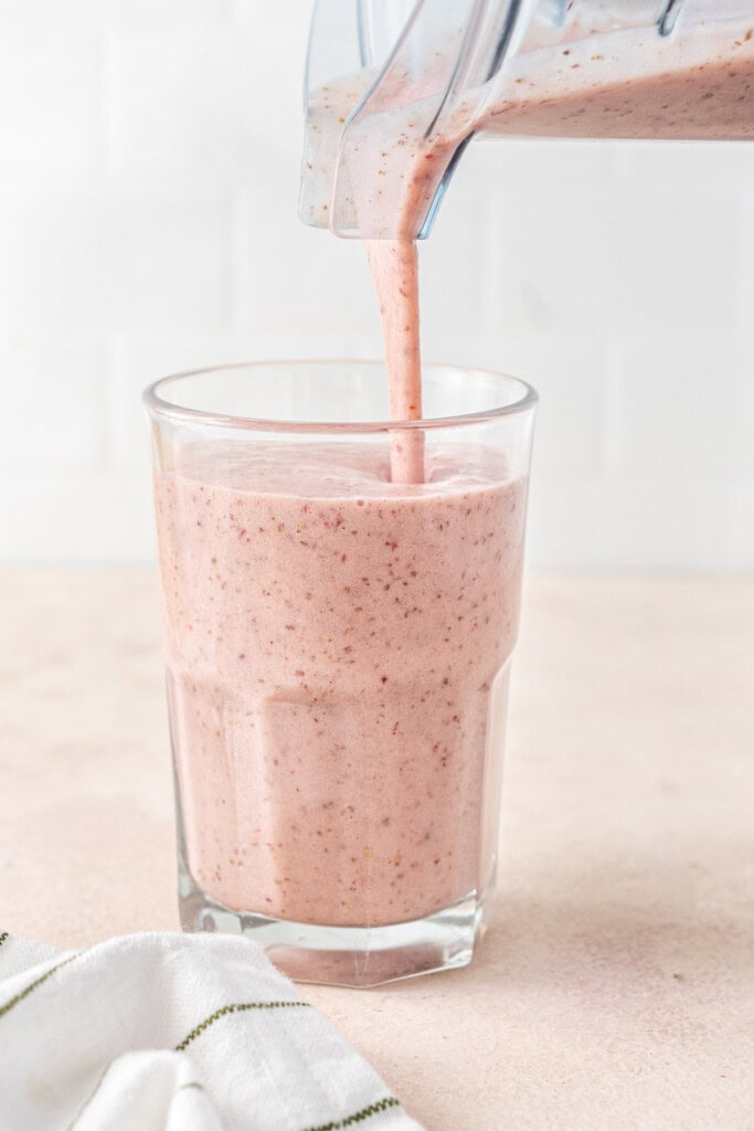 Pouring the smoothie into the glass.