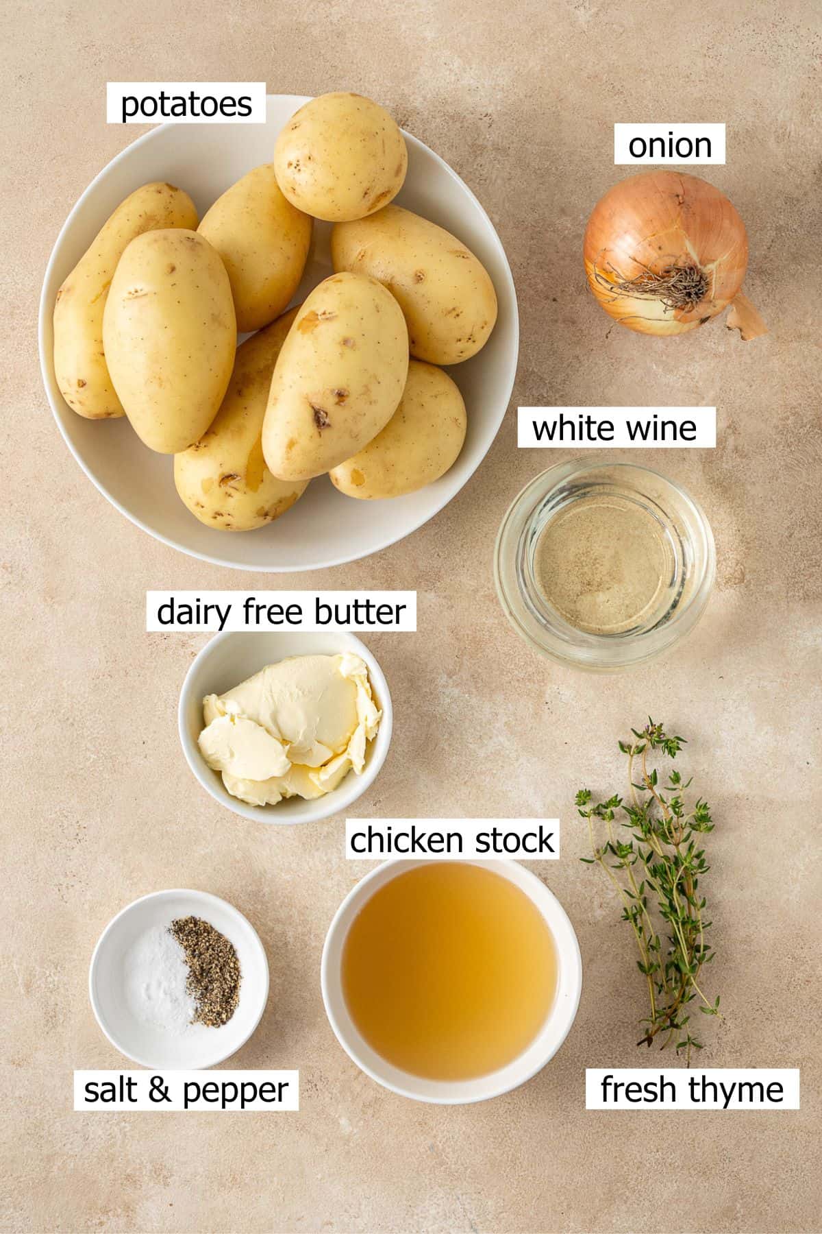 All ingredients needed to make Boulangère potatoes laid out in bowls.