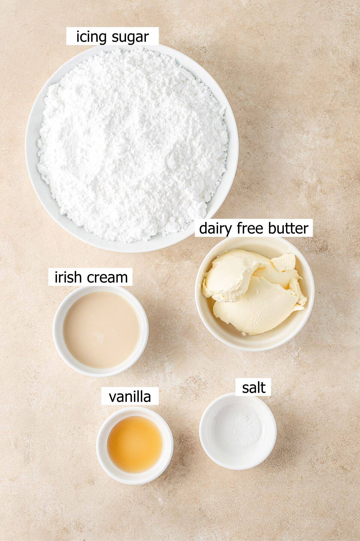 All ingredients needed to make Irish cream buttercream frosting laid out in small bowls.
