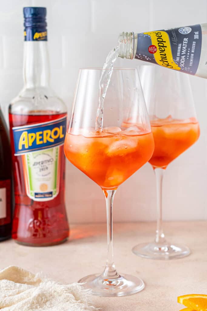 Pouring soda water into the glass.