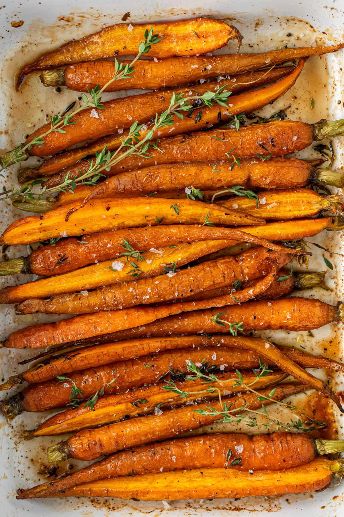 Close up of the roasted carrots with maple syrup in a baking dish.