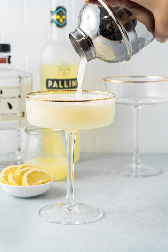 Straining the cocktail into a couple glass.