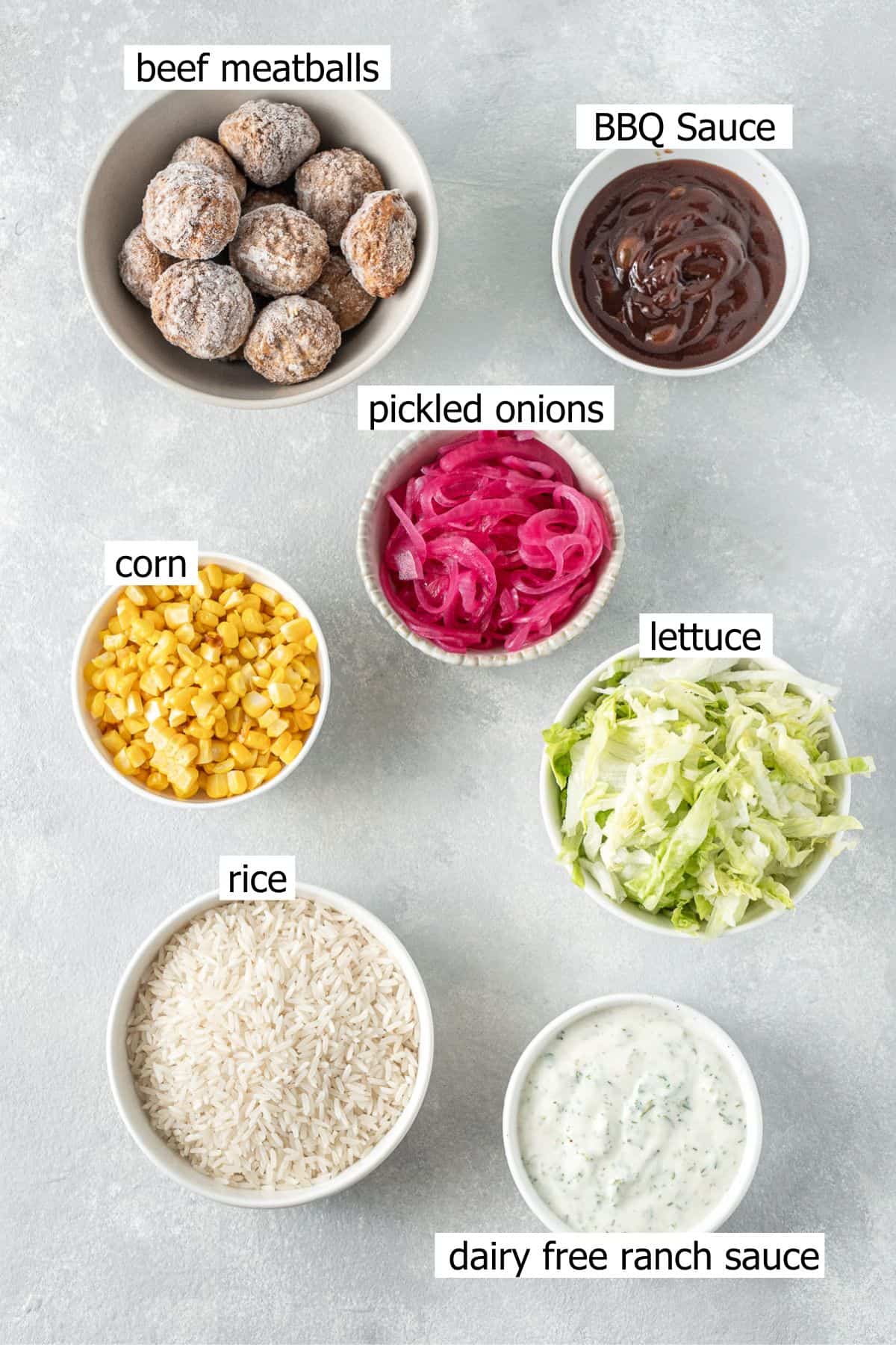 All ingredients needed to make BBQ beef meatball rice bowls laid out in small bowls.