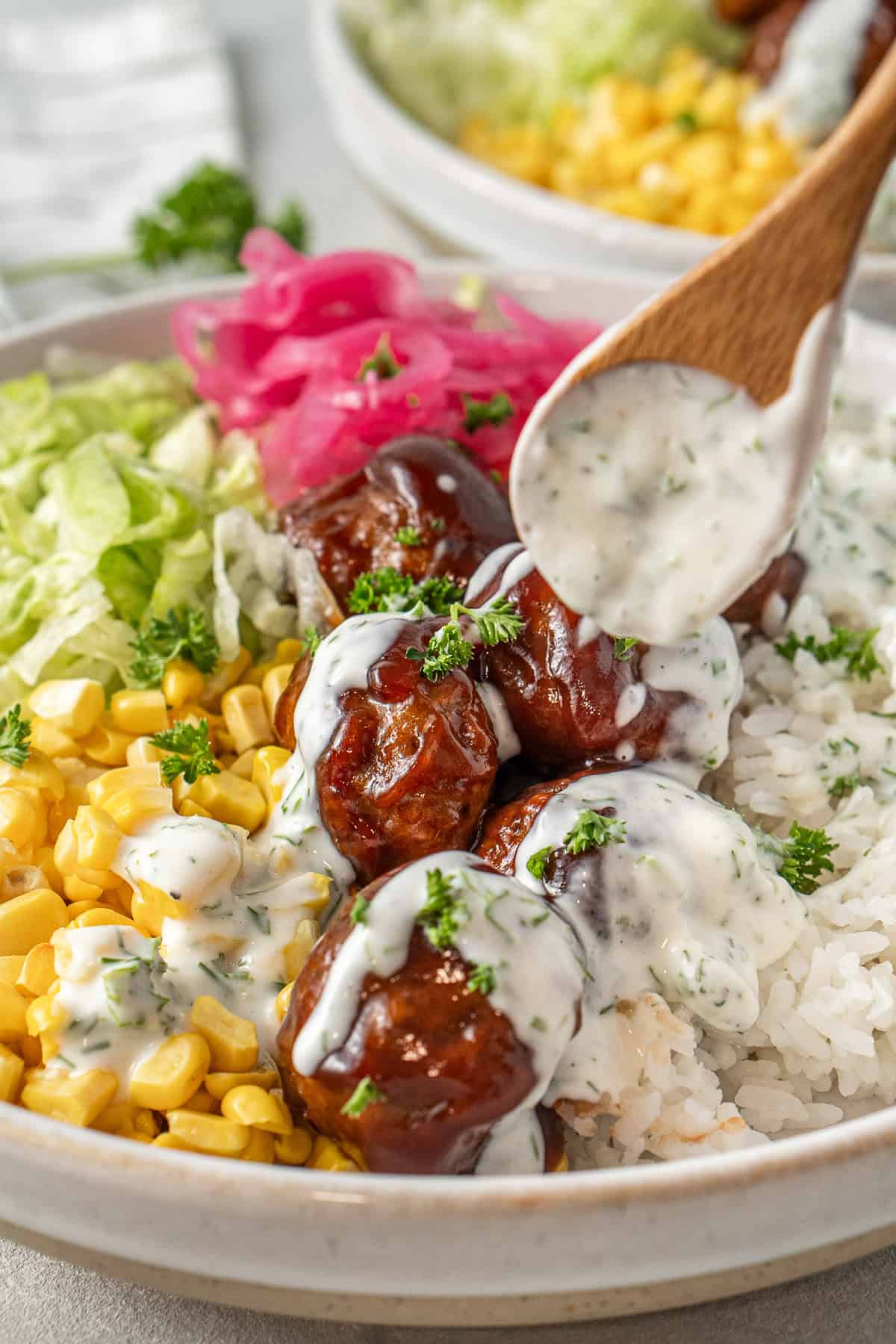 Drizzling ranch over the BBQ beef meatballs.