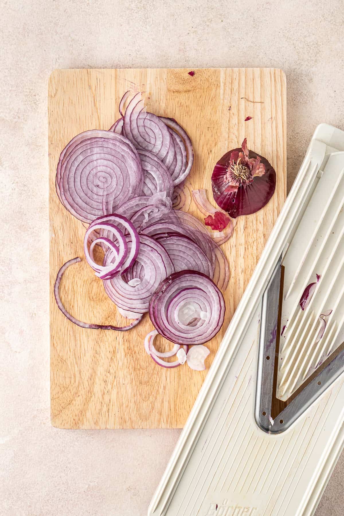 Slicing the red onions using a mandoline.