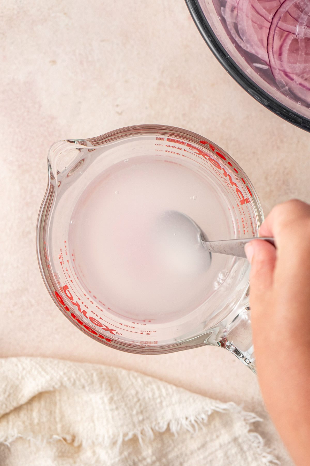 Mixing together the pickling liquid in a jug.