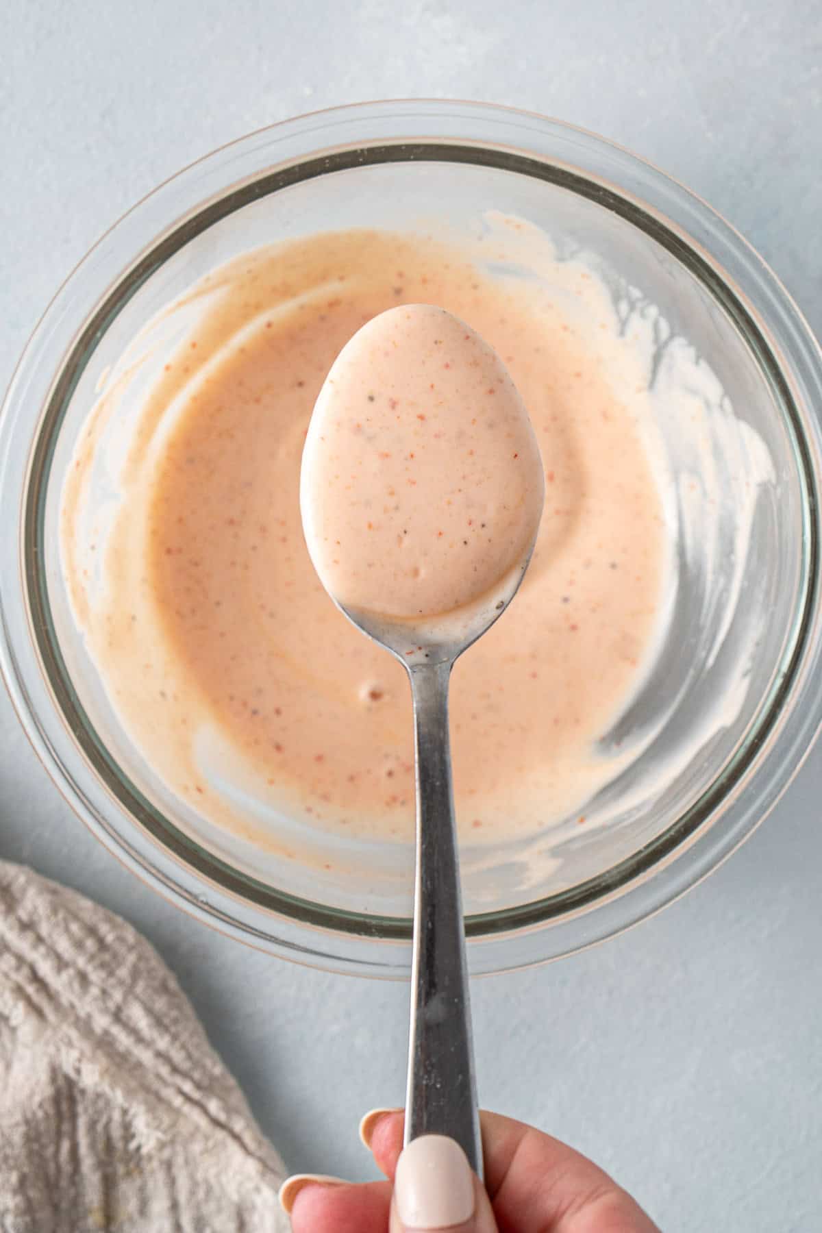 The fish taco sauce in a bowl with a spoon.