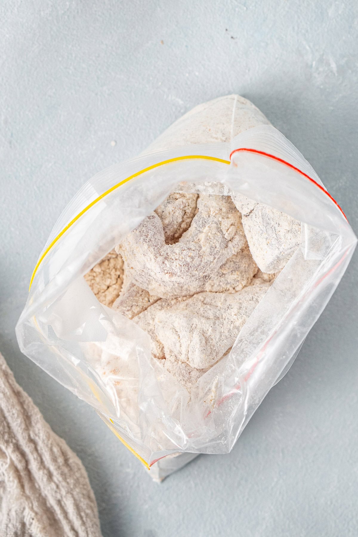 The fish pieces in a bag coated in flour.