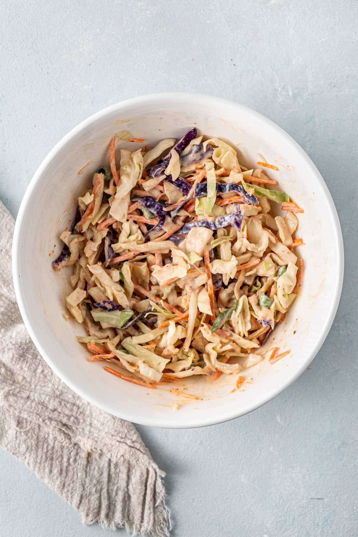 The dressed slaw in a white bowl.