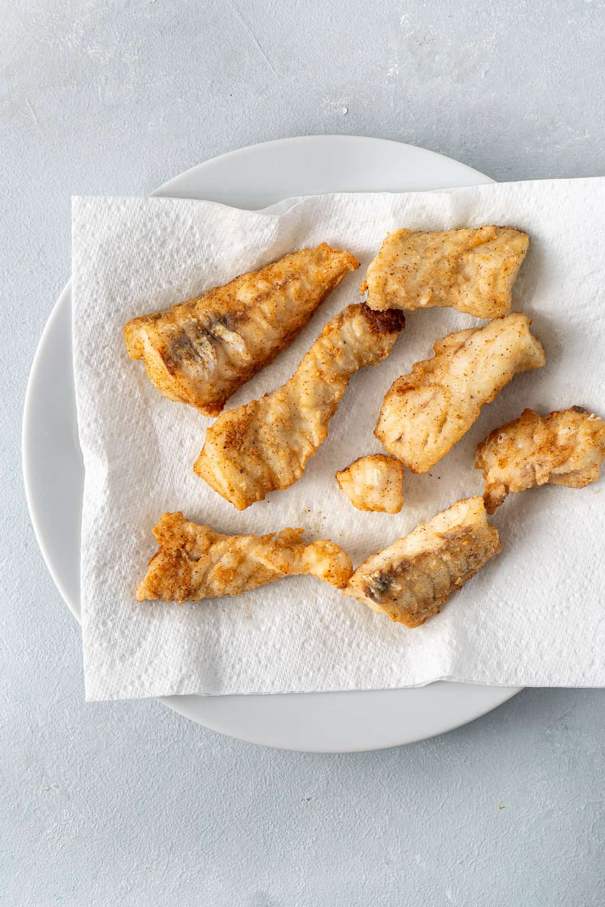 The fried fish on a plate with paper towel. 