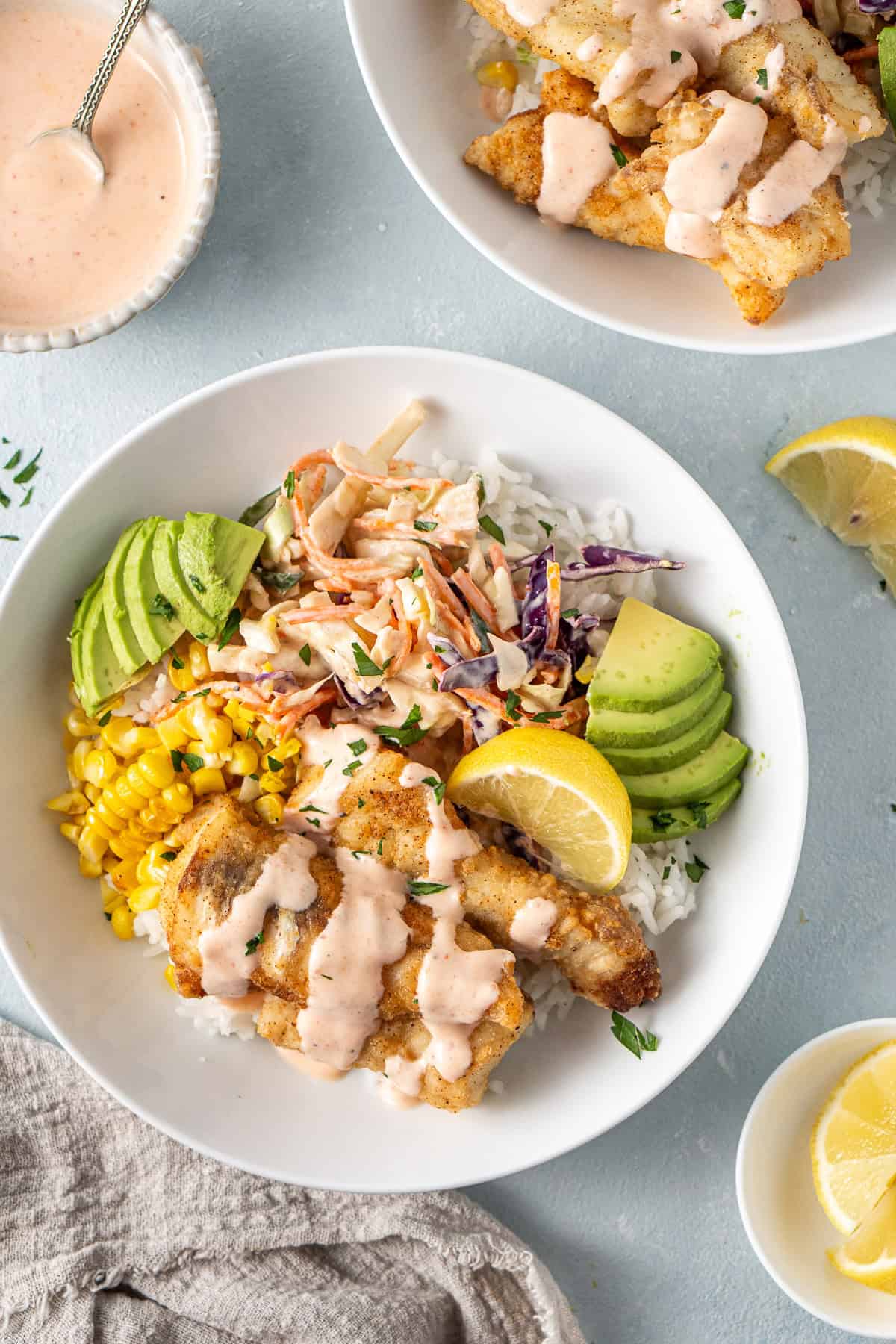 Close up of the assembled fish taco bowls with topping and sauce.
