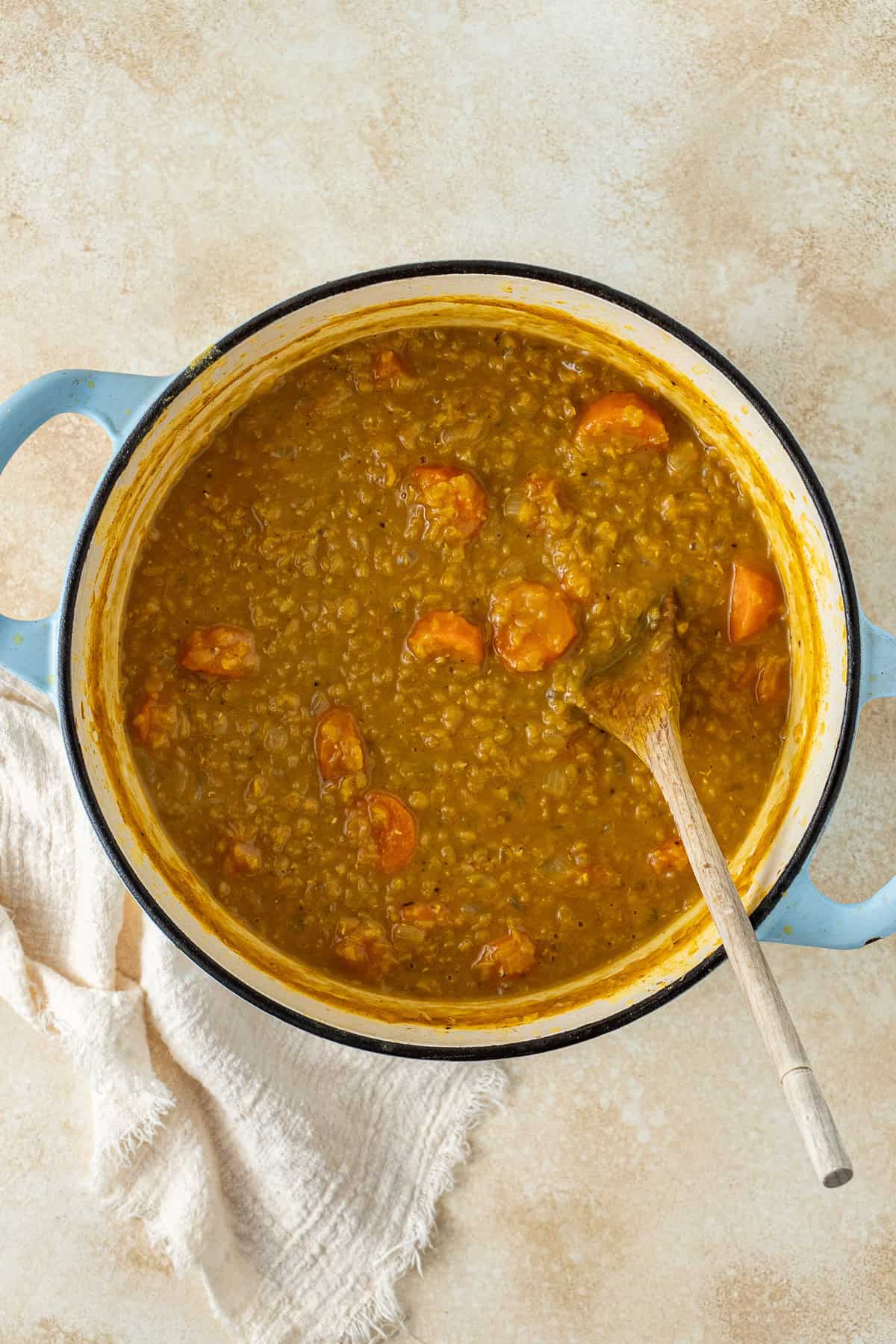 The cooked soup in the spot with the wooden spoon.