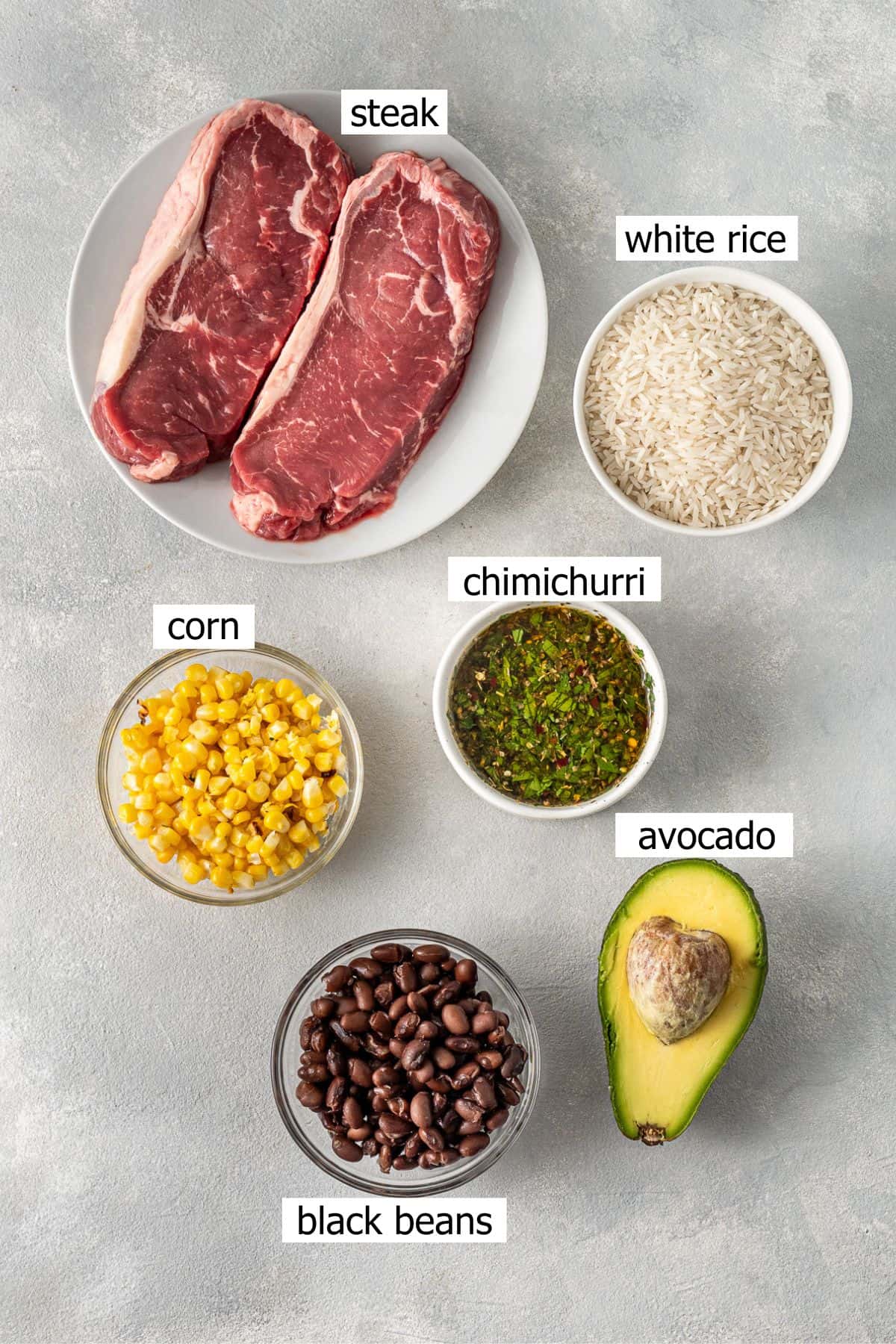 All ingredients needed to make steak rice bowls laid out in bowls.