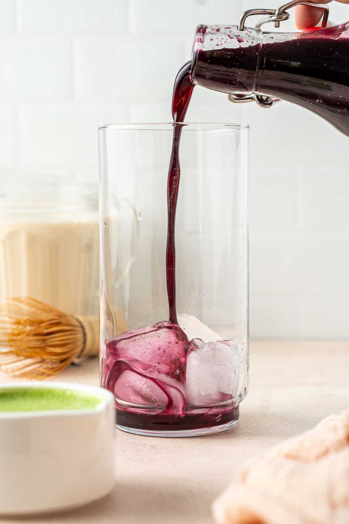 Pouring the blueberry syrup over ice.