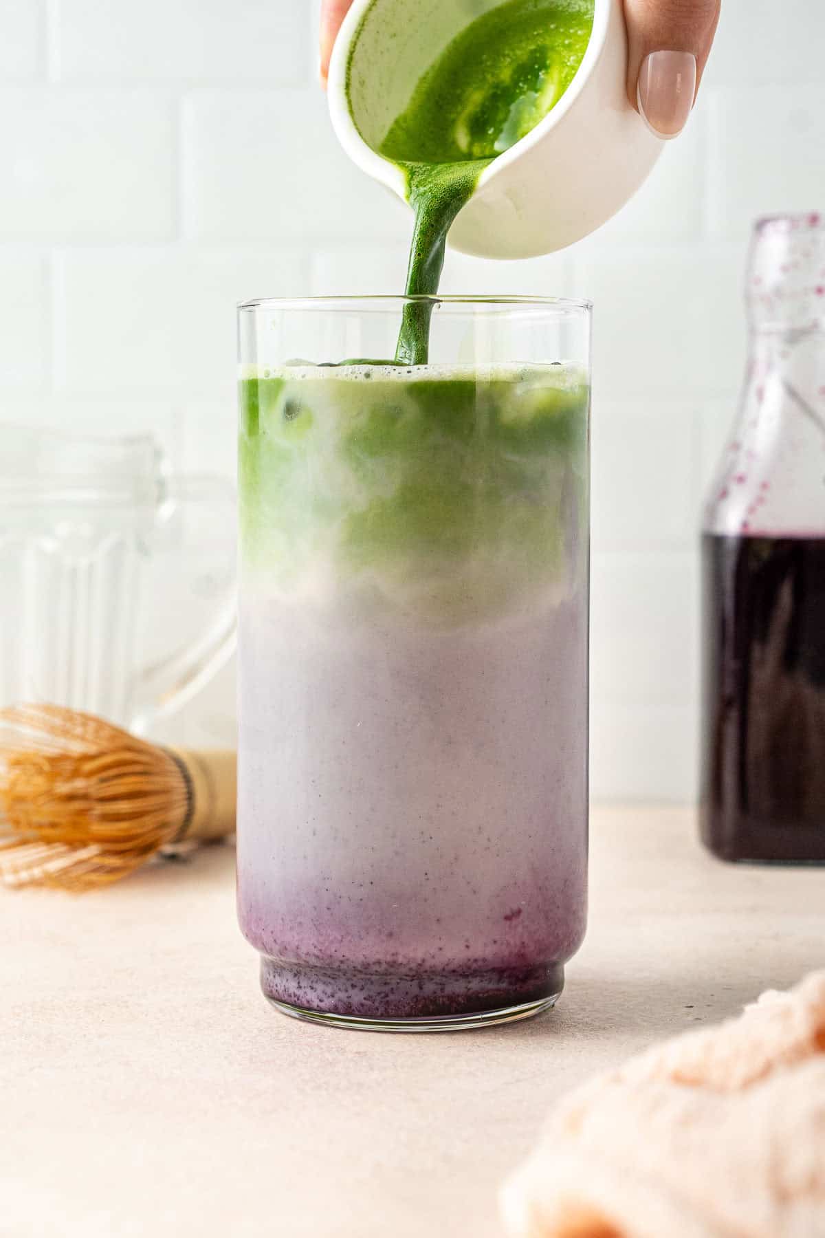 Adding the matcha to the glass showing the swirl of colours.