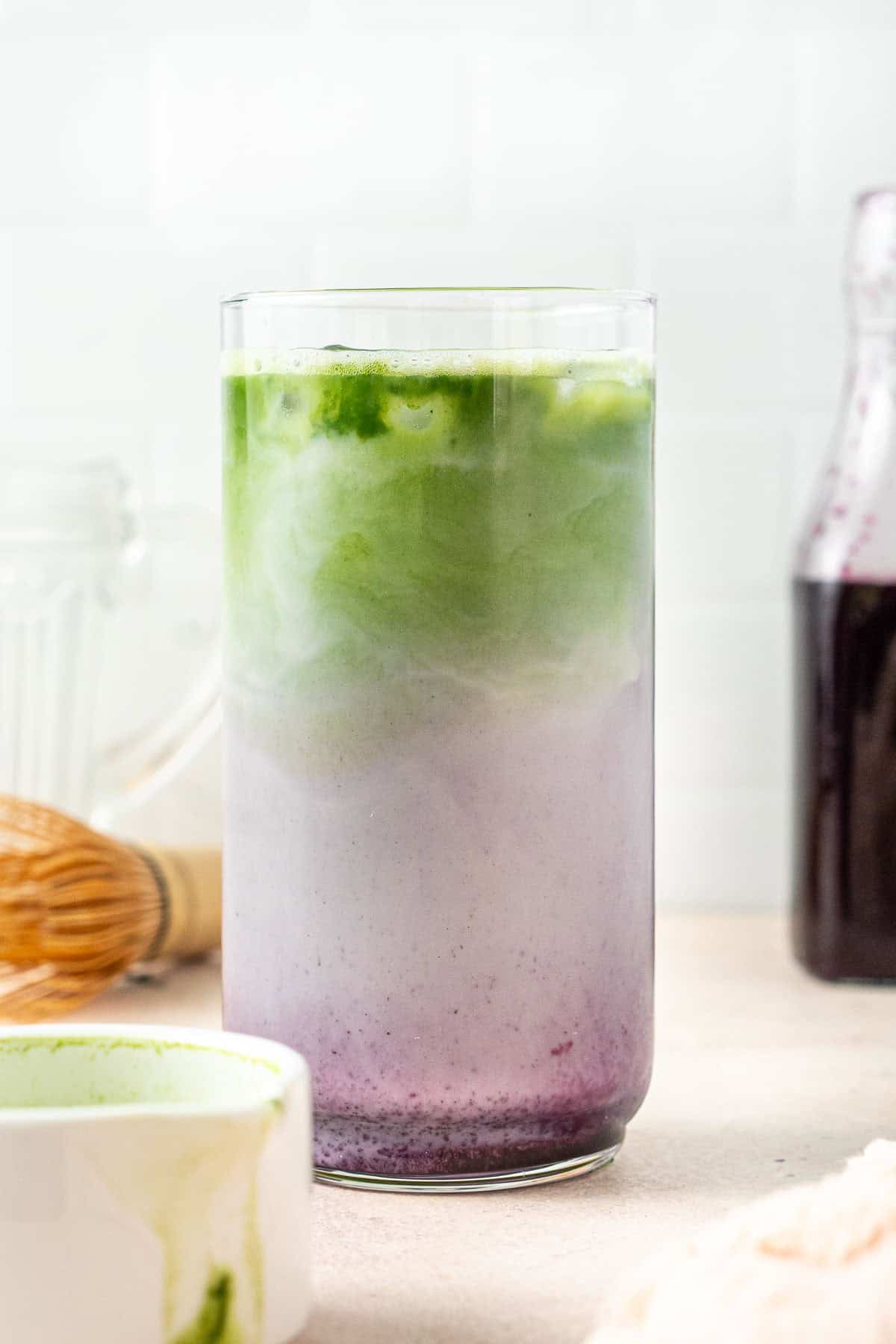 The iced blueberry matcha latte in a tall glass.